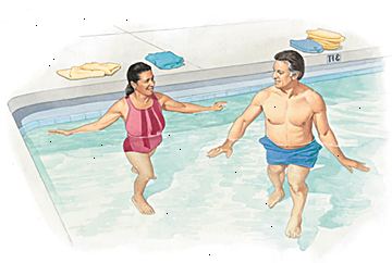 Άνδρας και γυναίκα με τα πόδια στο ρηχό τέλος της πισίνας.